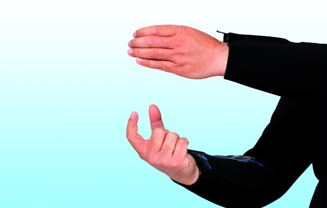 Boje aufblasen
Die linke Handfläche wird auf Brusthöhe ausgestreckt, die Finger sind dabei leicht gekrümmt („Boje halten“). 
Die rechte Hand ahmt das Halten des Oktopusses nach (Zeigefinger und Daumen leicht abgespreizt), der Zeigefinger drückt symbolisch die Luftdusche.